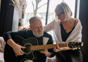 elderly couple playing guitar
